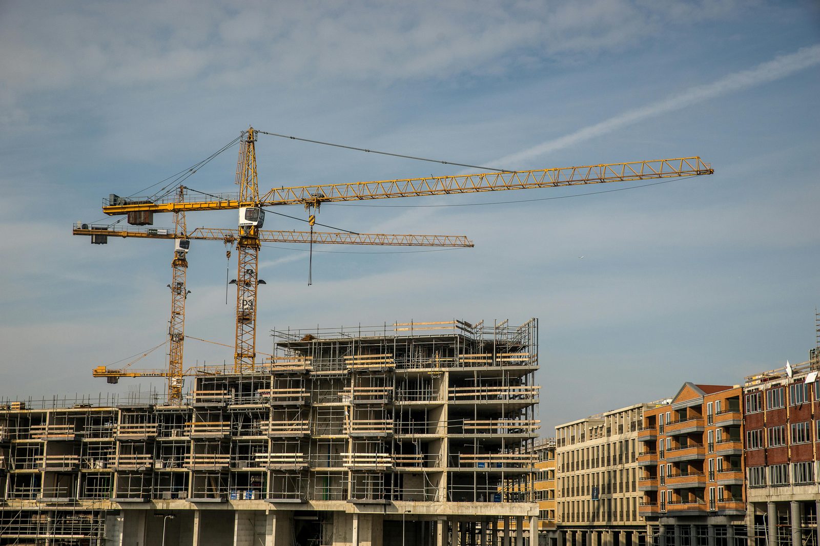 Chantier de logement neuf en construction VEFA avec grues et échafaudages