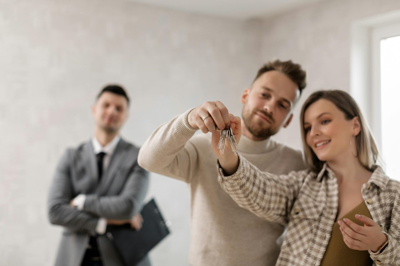 Couple recevant les clés de son logement neuf VEFA en présence d'un conseiller Swap Immobilier